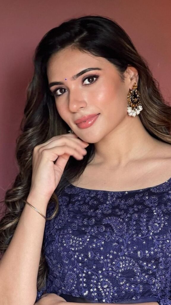 Elegant woman in a blue embroidered ethnic outfit with statement earrings and soft makeup